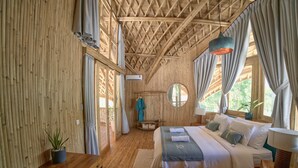 A wooden room with a bed, a desk, and a window. - Villa Tokay - The Luxury Resort (Gili Air)