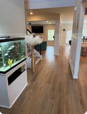 A spacious living area with a fish tank, staircase, and a television. - Modern 4 bedrooms Luxury Home (Atlanta)