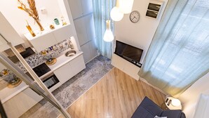 Un salon moderne avec un canapé, un téléviseur et une cheminée.