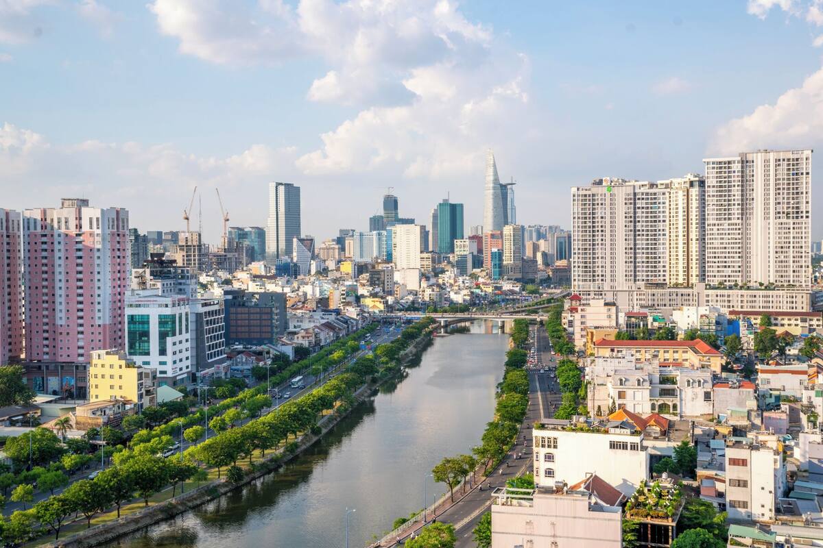 A cityscape with a river, modern high-rise buildings, and a mix of residential and commercial structures.