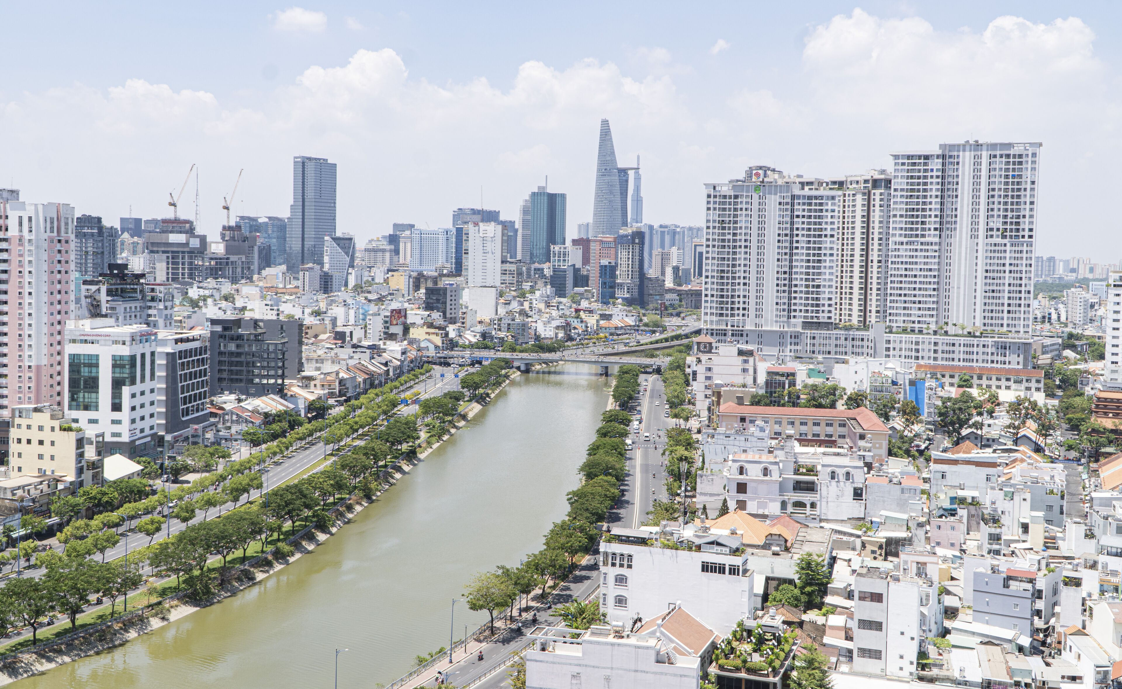 Un paysage urbain comprenant une rivière, des immeubles modernes de grande hauteur, ainsi qu’un mélange de bâtiments résidentiels et commerciaux.