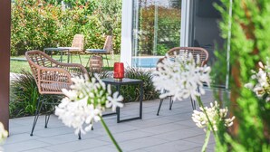 An outdoor patio with wicker chairs, a table, and a red vase. - Villa 'My Lagozise' with Private Pool, Wi-Fi and Air Conditioning (Pacengo)