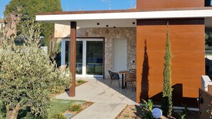 A modern house with a stone facade, a flat roof, and a patio with outdoor furniture. - Villa 'My Lagozise' with Private Pool, Wi-Fi and Air Conditioning (Pacengo)