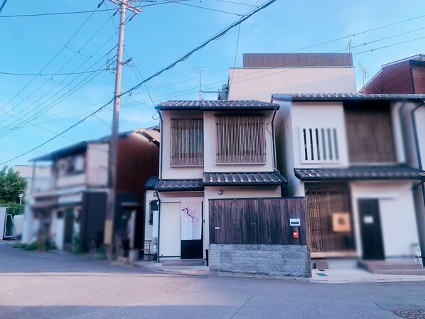 A row of traditional Japanese buildings with distinct architectural styles, including wooden slats and tiled roofs. - touyouan momo house (Kyoto)