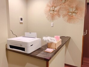 A printer on a desk with a decorative wall piece above it. - touyouan momo house (Kyoto)