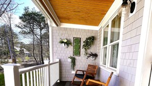 A porch with a wooden floor, white railings, and two rocking chairs. - National Seashore/Updated/Game Room~Blue Pearl (Eastham)