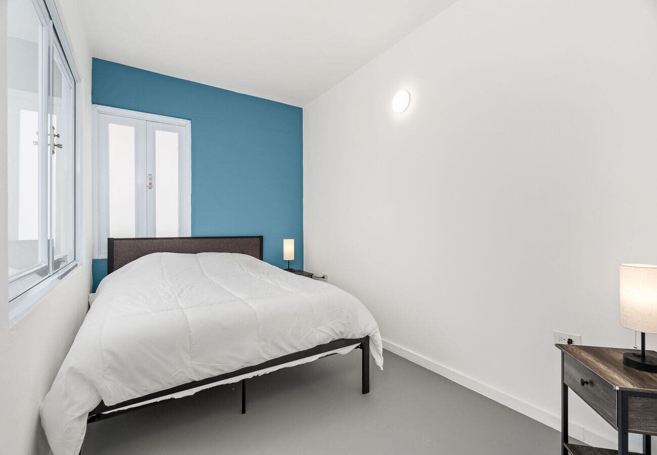 Queen bedroom with accent wall & bedside lamp