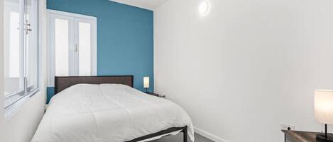 Queen bedroom with accent wall & bedside lamp