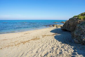A sandy beach with clear blue water and rocky outcrops. - 2-Bedroom Apartment 100m from the Beach - Private Terrace - Fiber Wi-Fi - A/C (Linguizzetta)