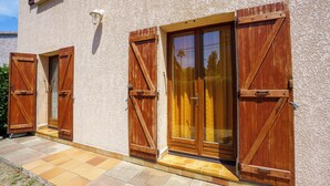 A building with wooden shutters on the windows and a tiled entrance.