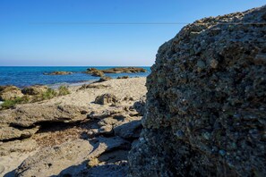 A rocky shoreline with clear blue water and distant land. - 2-Bedroom Apartment 100m from the Beach - Private Terrace - Fiber Wi-Fi - A/C (Linguizzetta)