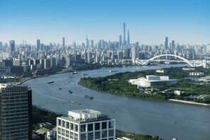 A cityscape with a river, modern buildings, and a distinctive bridge. - MGM Shanghai West Bund (Shanghai)