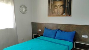 A bedroom with a bed, two nightstands, a wall-mounted artwork, and a window with blinds. - Cozy villa with large private pool and complete barbecue (El Mirador del Penedès)