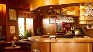 A bar area with wooden furnishings, a Coca-Cola refrigerator, and a variety of glassware. - Guest House Pri Cesarju (Kamnik)