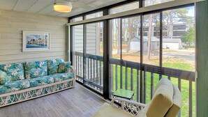 A covered porch with a sofa and a chair, a small table, and a framed picture on the wall. - 2 Blocks from the Beach and Ocean! Updated 2 bedroom Condo with Pool! Our Place at the Beach #H107 (Ocean City)