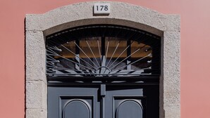 A double door with a number plate above it, set in a stone archway.