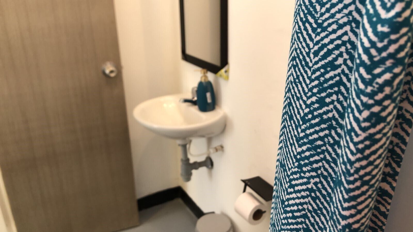A bathroom with a white sink, a mirror, and a towel rack.