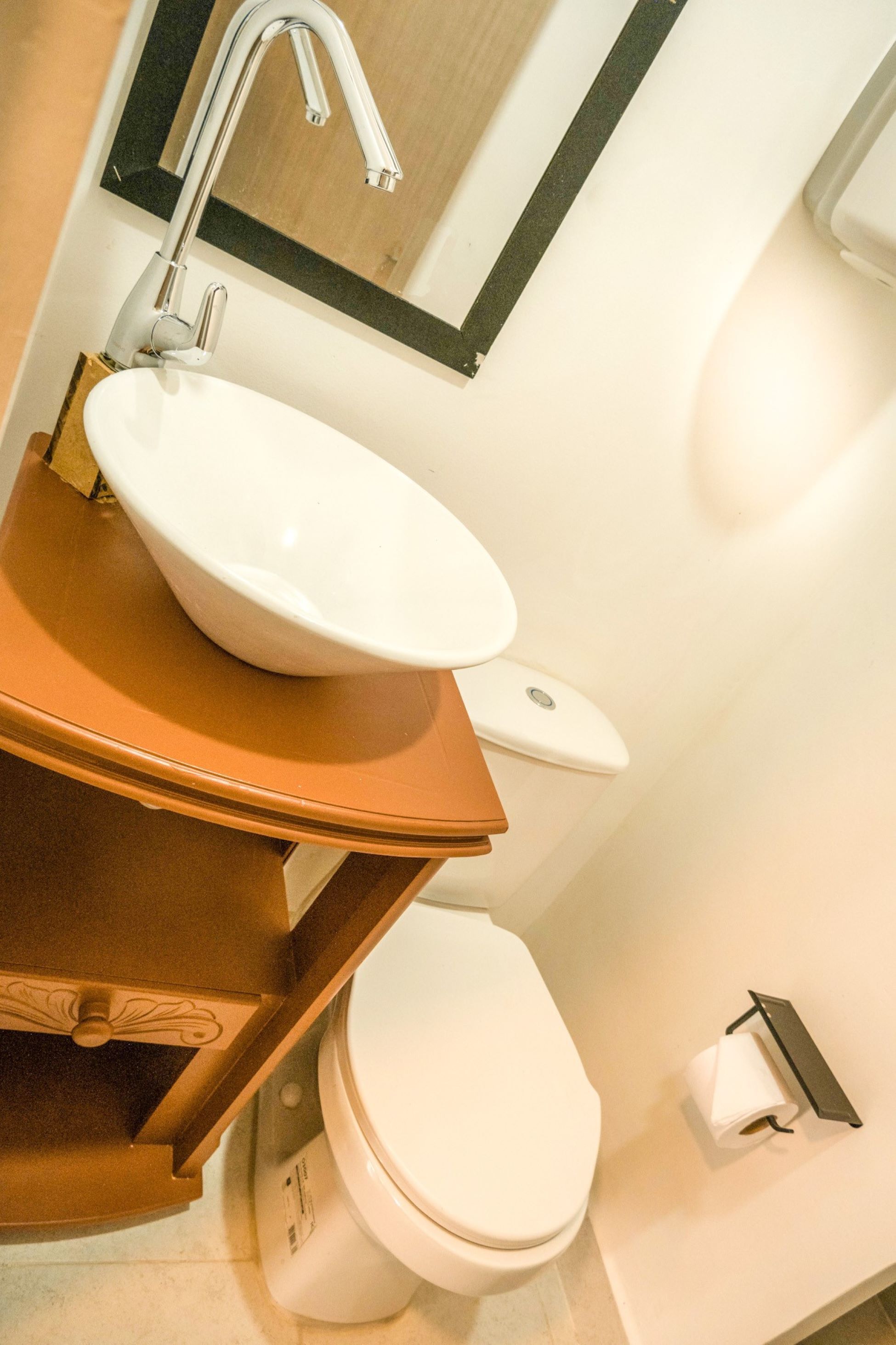 A bathroom with a white sink, a mirror above it, and a toilet.