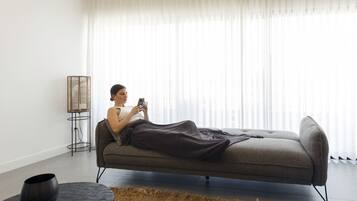 Een moderne woonkamer met een bank, een salontafel en een vloerlamp.