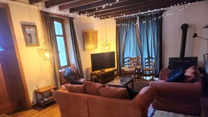 Ett mysigt vardagsrum med en soffa, ett soffbord, en tv och en öppen spis.