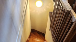 En trätrappa med ett ledstång och en lampa monterad högst upp.