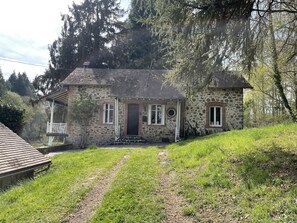 Een stenen huis met een veranda, een voordeur en een klein raam.