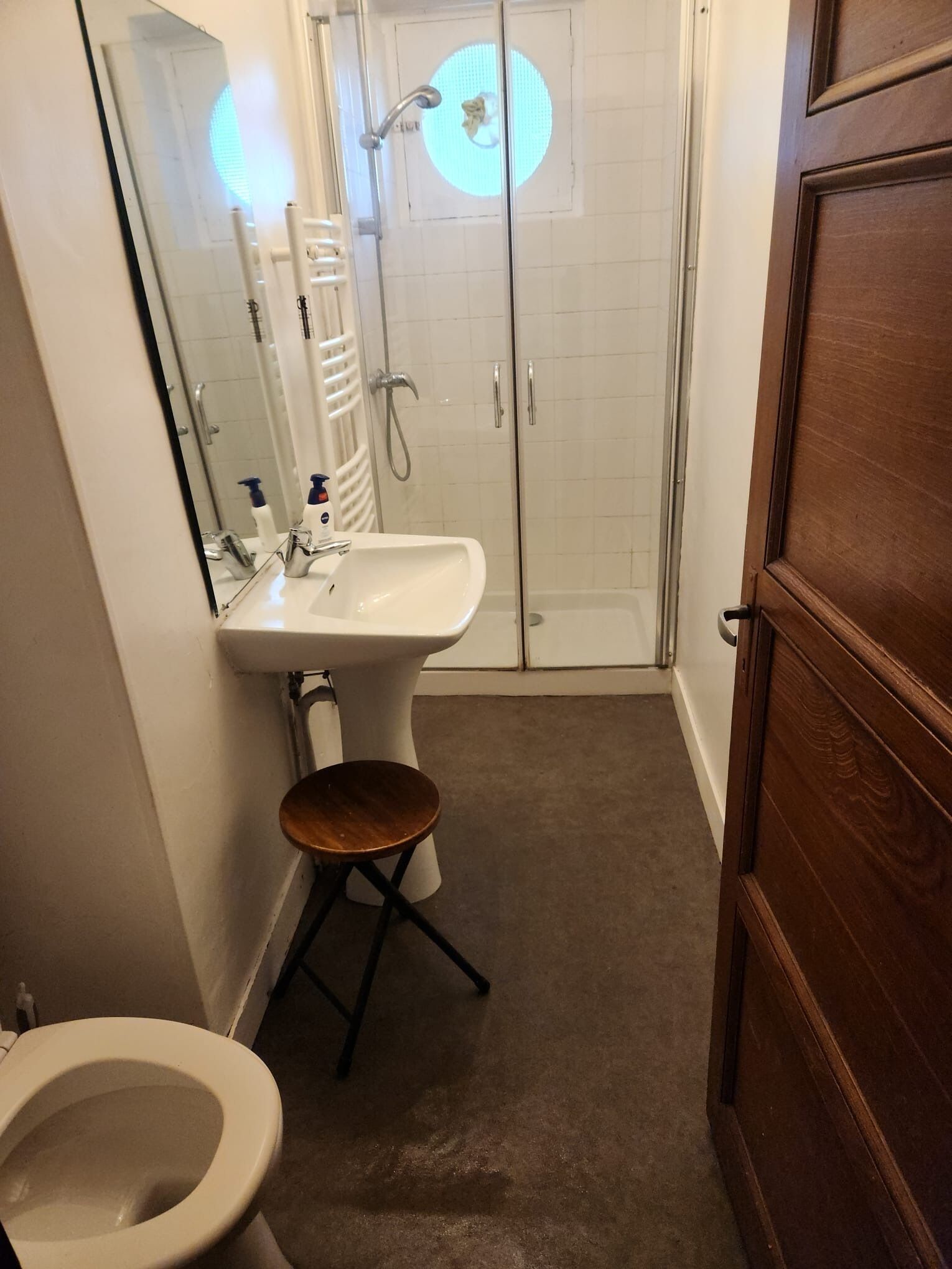 A bathroom with a toilet, sink, and shower.
