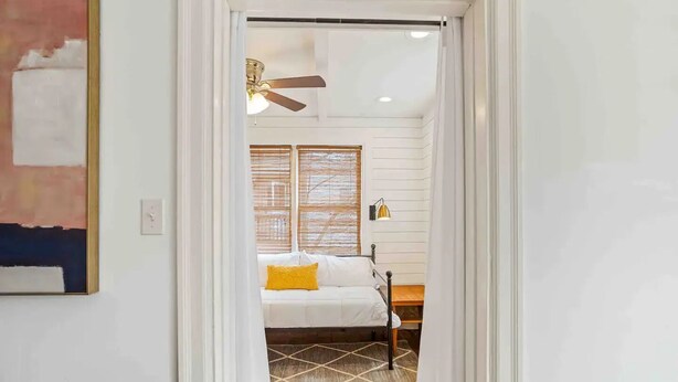 A bedroom with a bed, a ceiling fan, and a window with blinds. - Vulcan View Cottage (Birmingham)