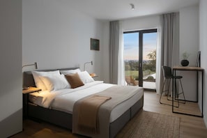 Un dormitorio moderno con una cama grande, mesitas de noche, un escritorio con silla y vistas al exterior a través de un ventanal corredero.