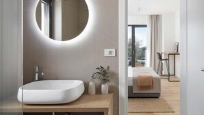 A modern bathroom with a round mirror, a white sink, and a wooden vanity. - Villa Sealine in Vinkuran (Vinkuran)