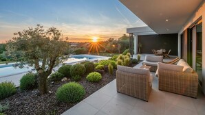 A modern outdoor living area with a pool, outdoor furniture, and a view of the sunset. - Villa Sealine in Vinkuran (Vinkuran)