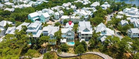 An aerial view of a residential area with houses, a beach, and a 4-minute bike ride to a beach club.