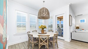 A dining area with a round table, six chairs, and a hanging light fixture. - *SPECIAL* Summer Salt 38*NEW* SLEEPS 19 4 bed 4.5 bath home Orange Beach (Orange Beach)
