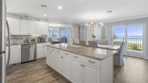 Una cocina moderna con armarios blancos, electrodomésticos de acero inoxidable y una isla grande.