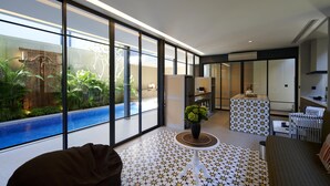 A modern hotel room with large windows, a pool view, a small round table with a plant, and a patterned floor. - Adamare Villa Umalas (Kerobokan)
