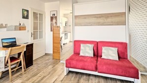 A modern living room with a red sofa, a wooden desk, and a laptop. - Charme de Villès Martin by Interhome (Saint Nazaire)