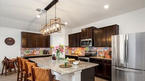 Una cocina moderna con armarios de madera oscura, electrodomésticos de acero inoxidable y un salpicadero colorido.