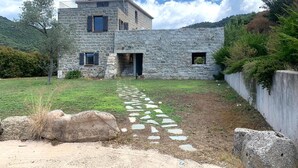 Un bâtiment en pierre avec un chemin en pierre menant à l’entrée.
