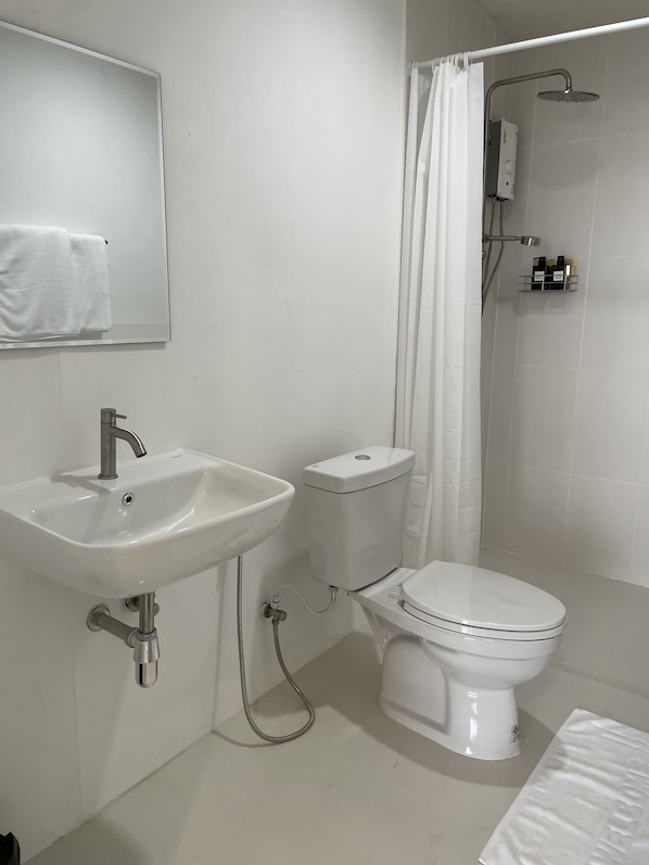 A modern bathroom with a sink, toilet, and shower.