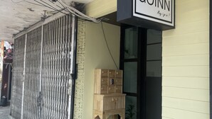 Un edificio con un letrero que dice "GOINN" y un mueble de madera en el exterior.