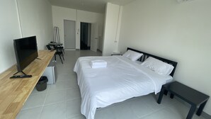 Una habitación de hotel con cama, televisión, escritorio y silla.