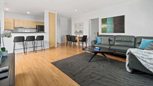 Un appartement moderne comprenant un coin repas, une cuisine et un salon.
