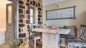 Ein rustikaler Raum mit Steinwand, Holztisch und Bank.