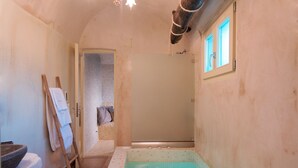 Ein Badezimmer mit einer Badewanne, einer Holzleiter und einem Handtuchhalter.
