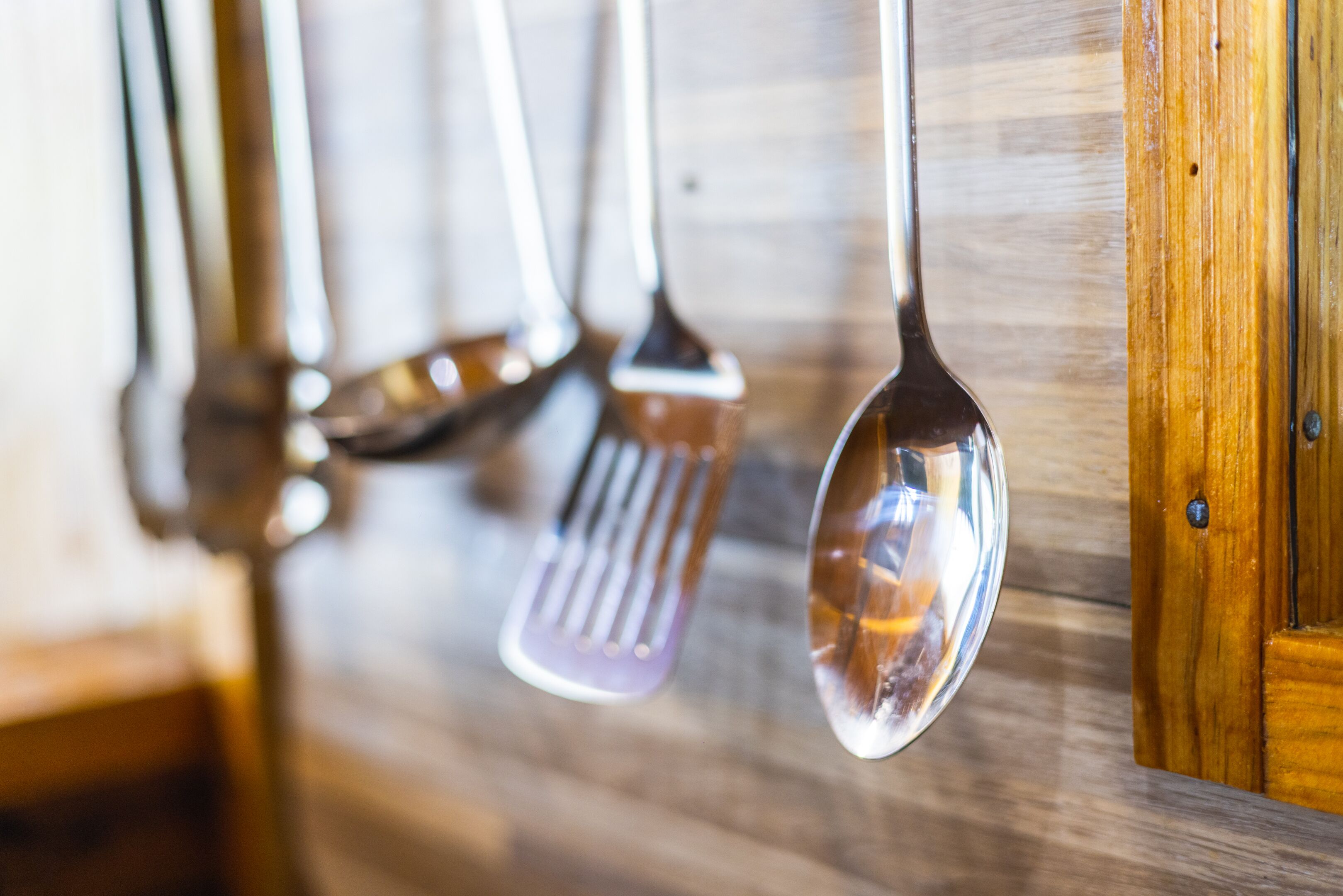 Una cocina con armarios de madera y utensilios colgantes.