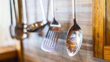 Una cocina con armarios de madera y utensilios colgantes.