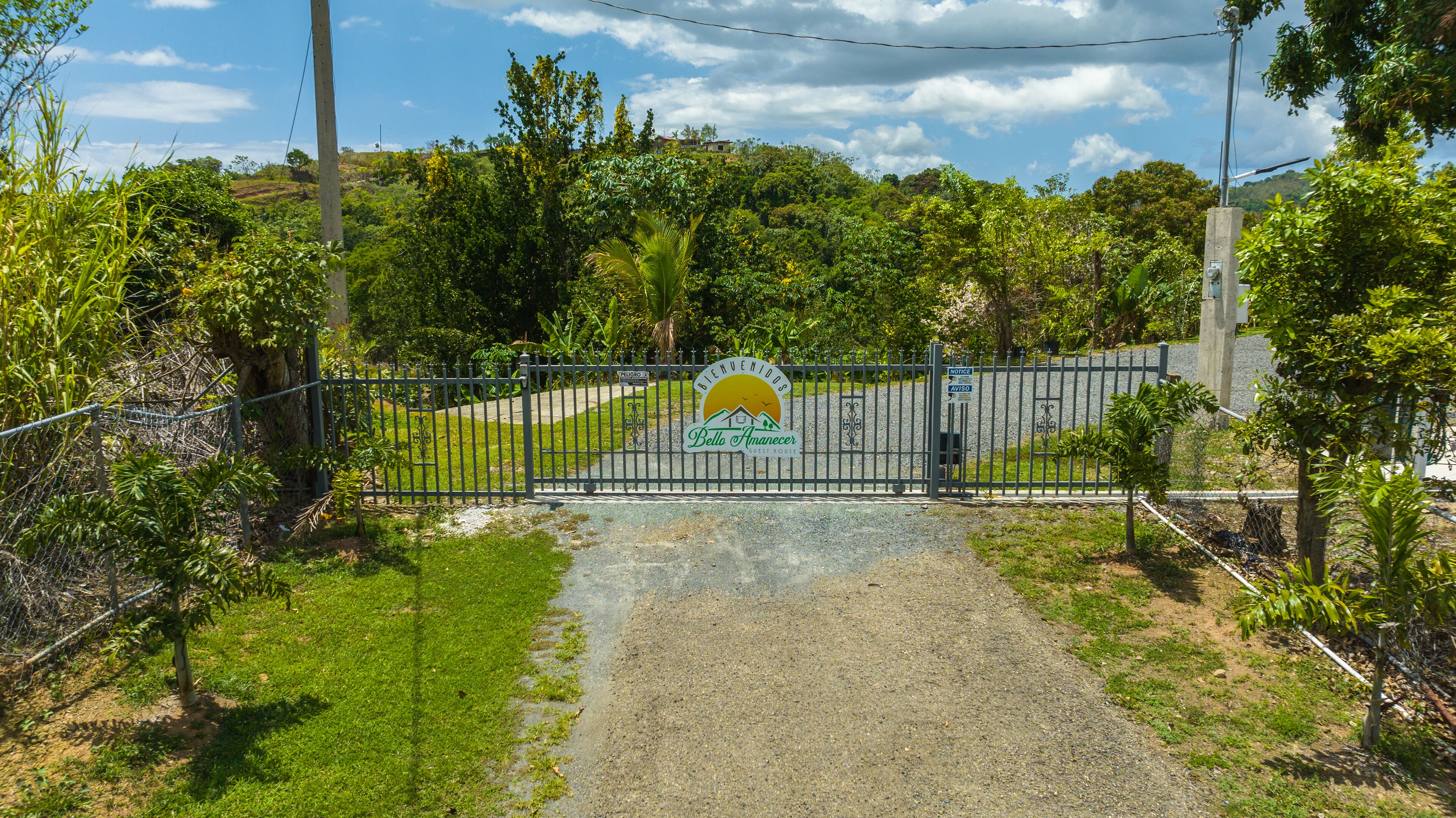 Uma entrada com portão e placa indicando uma residência para hóspedes.