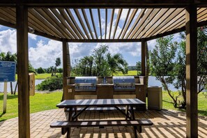 Ein Grillplatz im Freien mit Grill, Picknicktisch und Seeblick.