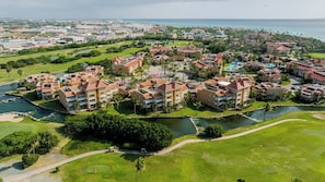 Un complexe hôtelier comprenant plusieurs bâtiments, un terrain de golf et une étendue d’eau.