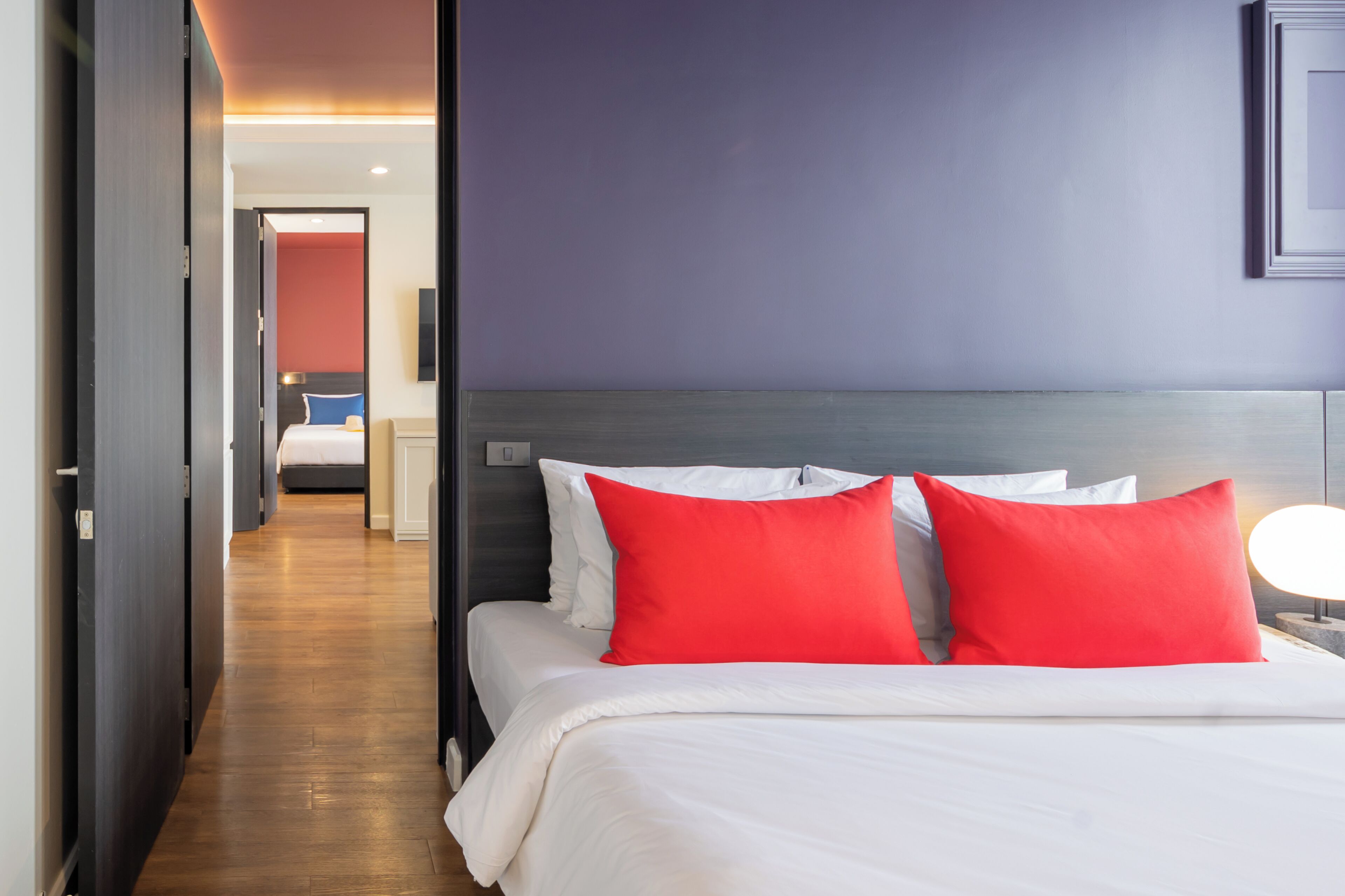 A hotel room with a bed, a nightstand, and a wall-mounted TV.
